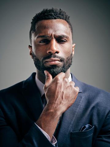 A studio portrait of a handsome black man in a business suit.