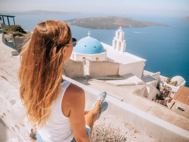 istock Woman contemplates Santorini from top, Greece 1301253990