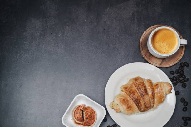 istock cup of coffee and Fresh baked croissant on old kitchen table. Top view with copyspace for your text. 1301254539