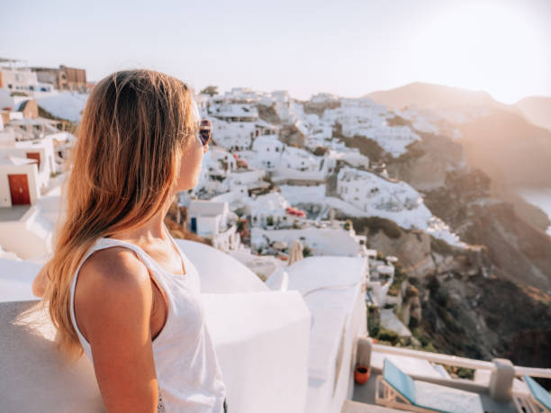 istock Woman contemplates Santorini from top, Greece 1301256066