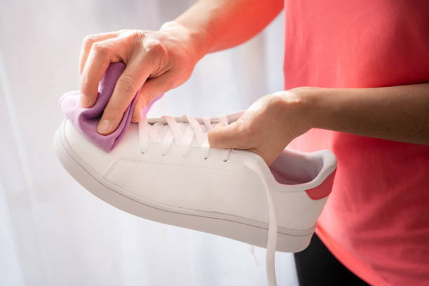 istock Cleaning white sneaker with purple cloth 1301256512