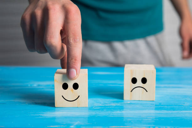 istock hand choose smiley face and  sad face icon on cube 1301256584