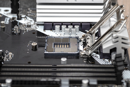 Macro shot of empty modern LGA 1200 socket for CPU on black desktop motherboard.