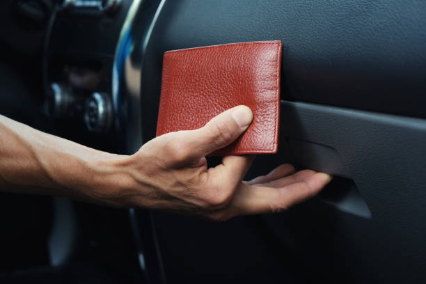 mano de hombre pone cartera de cuero en la guantera dentro del coche. - guantera fotografías e imágenes de stock