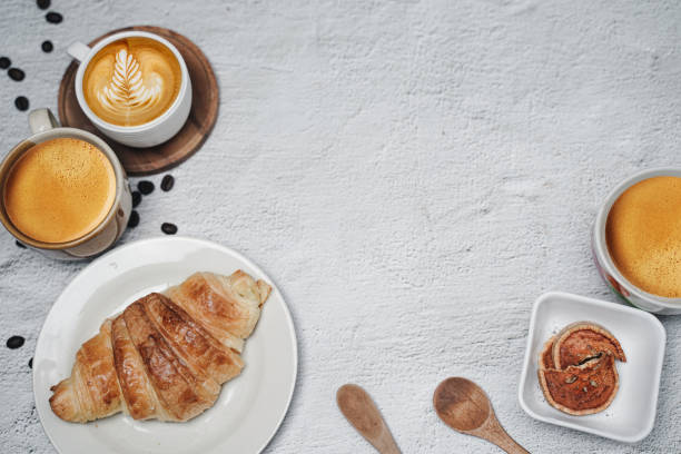 istock cup of coffee and Fresh baked croissant on white kitchen table. Top view with copyspace for your text. 1301257845
