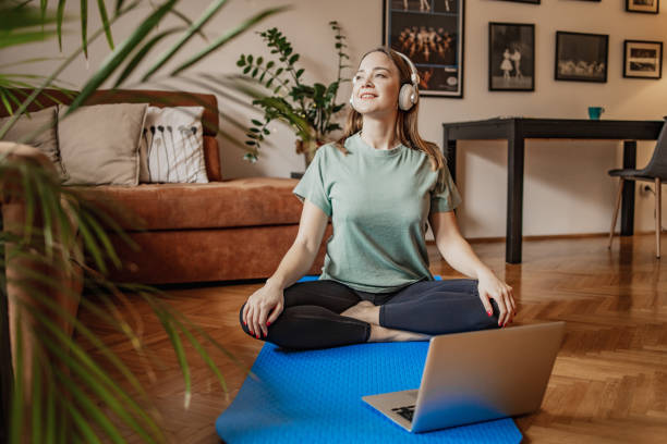 istock Young woman doing yoga at home 1301258167