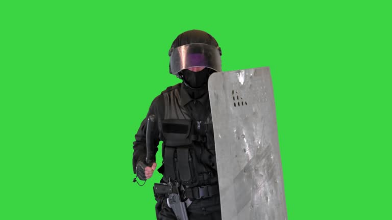 Soldier in full uniform with armor, baton, protective shield running on a Green Screen, Chroma Key