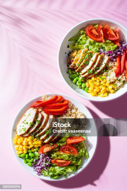 Grilled Chicken Breast With Brown Rice And Vegetables In White Plate Top View Pink Background Healthy Food Concept Stock Photo - Download Image Now