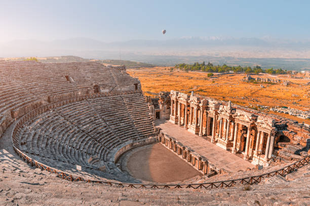 トルコのパムッカレ近くのイエラポリス市の古代ギリシャ円形劇場。驚異と旅行のアトラクション。朝の空の上の熱気球 - hierapolis ストックフォトと画像