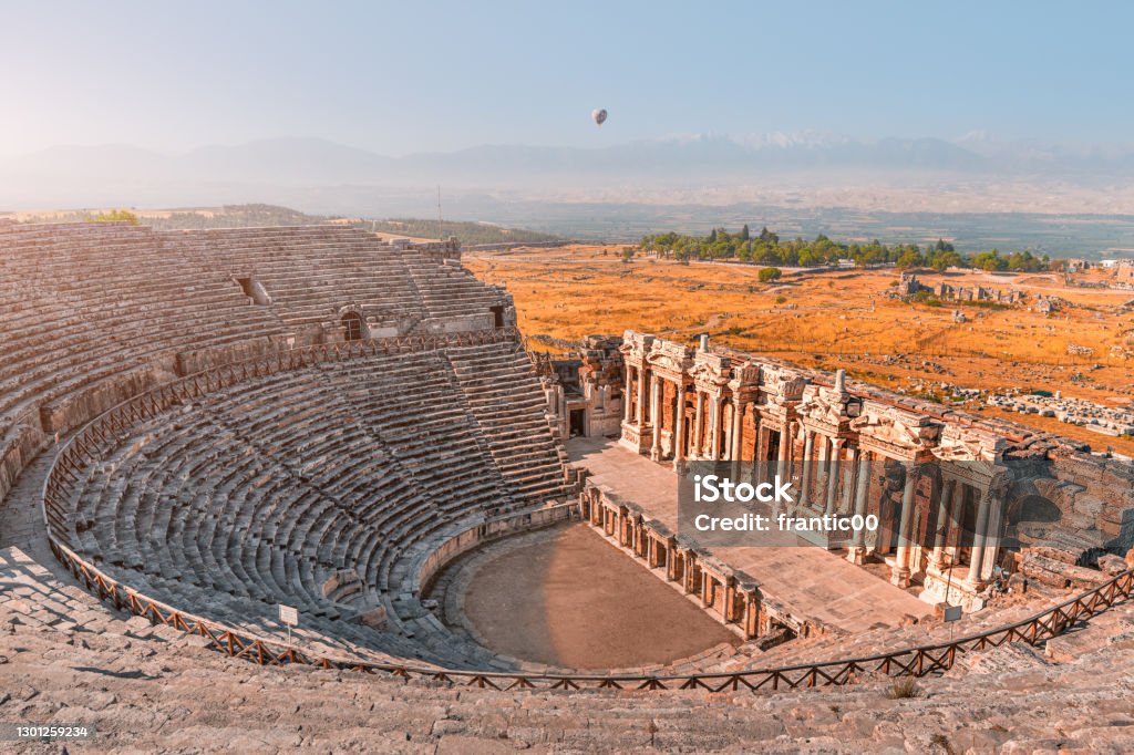 Ancient Greek amphitheater in the city of Hierapolis near Pamukkale in Turkey. Wonders and travel attractions. Hot air balloon above in the morning sky Pamukkale Stock Photo