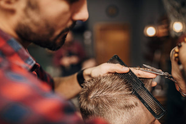 istock Barber cutting hair of the client with scissors 1301259669