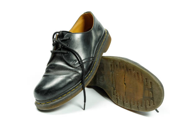 istock old, dirty, black leather shoes isolated on white 1301261564