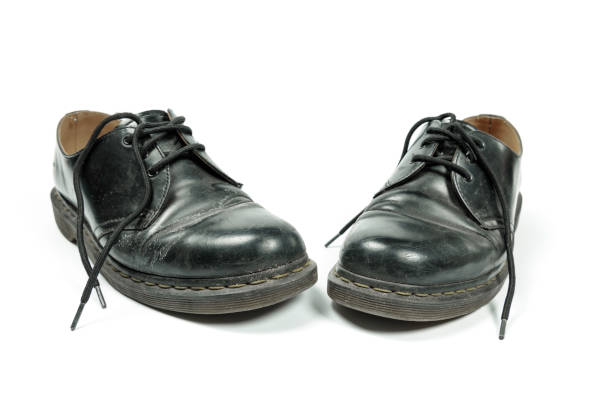 istock old, dirty, black leather shoes isolated on white 1301261574