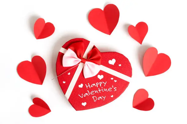 Happy valentines day, valentines day background with written note, heart shape gift box with ribbon and small paper hearts, on white background, valentines day card - top view