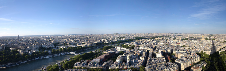 panoramic Paris taken from the top of the eiffel tower at a sunset and highlighting on the right the shadow of the tower