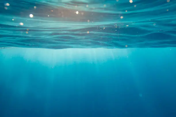 Photo of Clear blue aqua marine ocean with with light rays coming through water surface