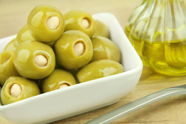 olives with almonds and oil close up - olive green olive stuffed food imagens e fotografias de stock