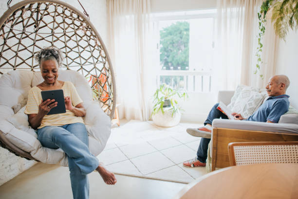 istock Senior couple at home - using digital tablet and reading book 1301266326