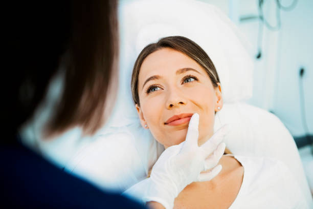 cosmetólogo preparando paciente para tratamentos faciais - exfoliating scrub - fotografias e filmes do acervo