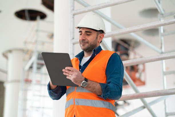 istock Male engineer working on the construction site with his helmet and vest notes things he considers important 1301267816