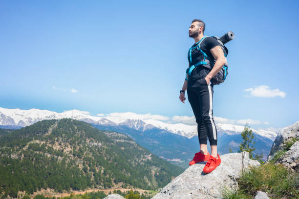 istock Traveler with a backpack standing on a mountain. 1301269230