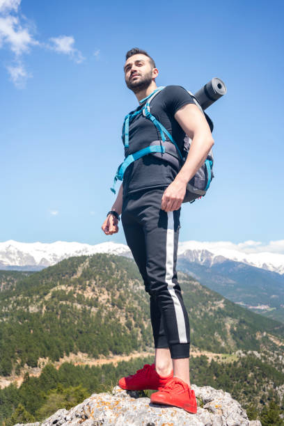 istock Traveler with a backpack standing on a mountain. 1301270094
