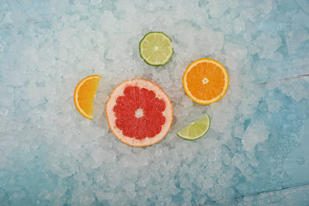 砕いた氷の上に新鮮な柑橘類のフルーツスライス - crushed ice colors grape fruit ストックフォトと画像