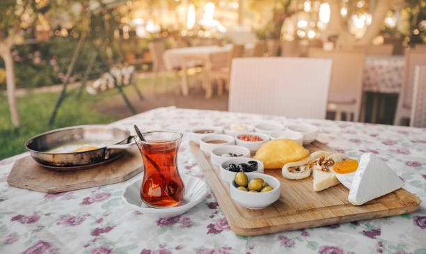 istock Freshly prepared Turkish Breakfast consisting of scrambled eggs, tea, vegetable salad and an assortment of snacks and pickles. Beautifully set table in the outdoor restaurant in the garden 1301274450
