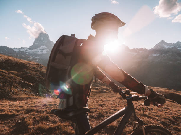 istock Female mountain biker admire the view from trail below the Matterhorn 1301275528