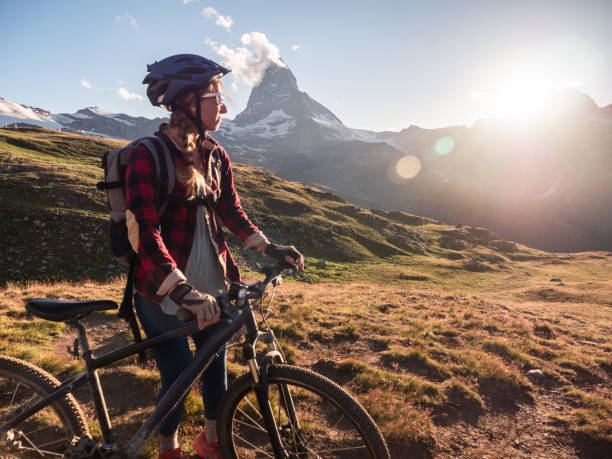 istock Female mountain biker admire the view from trail below the Matterhorn 1301275529