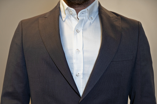 cropped portrait businessman,fashion. man in white shirt and suit button with hands close up