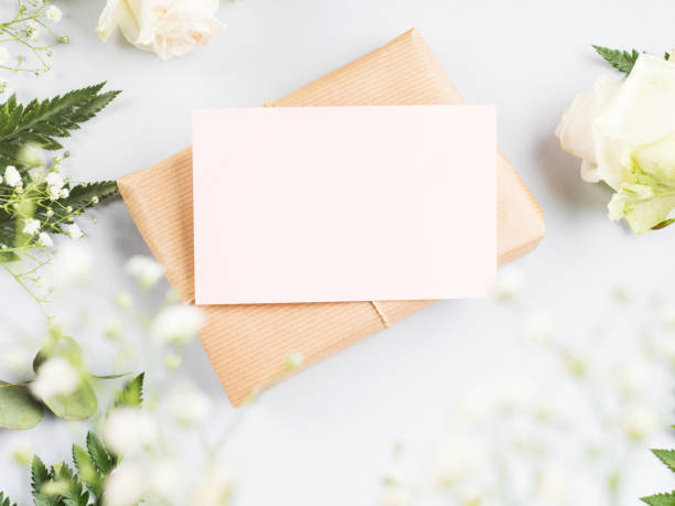 istock Wrapped craft gift box with blank pink card and flowers around 1301276478