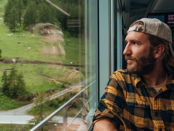 istock Man traveling by train looking from the window enjoying passing scenery 1301276538