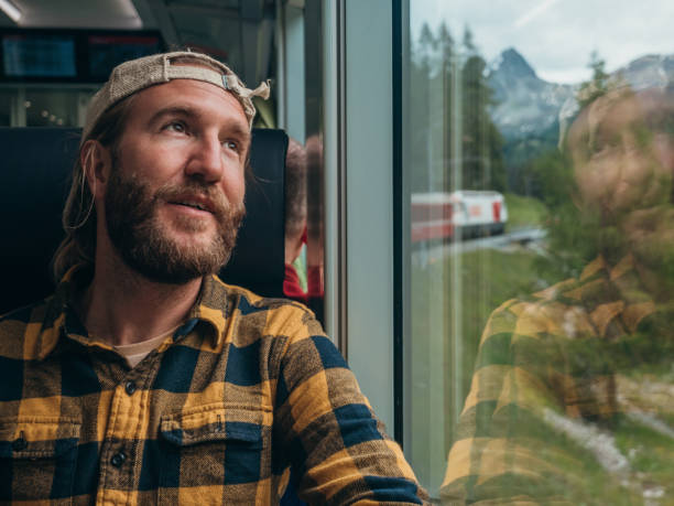 istock Man traveling by train looking from the window enjoying passing scenery 1301276580