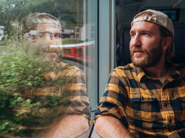 istock Man traveling by train looking from the window enjoying passing scenery 1301276652