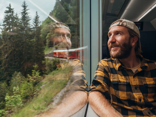 지나가는 풍경을 즐기는 창에서 바라보는 기차로 여행하는 남자 - graubunden canton switzerland station mountain 뉴스 사진 이미지