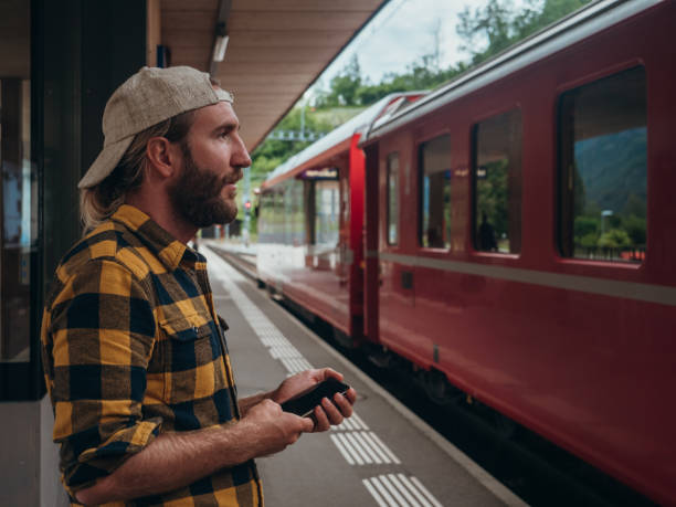 istock Man checks phone at train station 1301276712