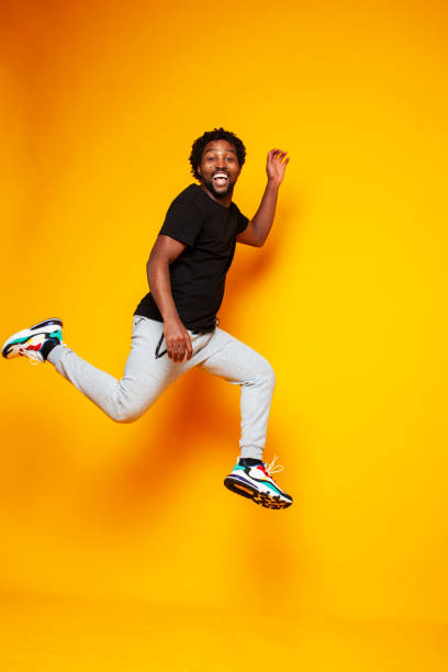 istock young handsome african american guy student posing cheerful and gesturing on yellow background, lifestyle people concept 1301276786