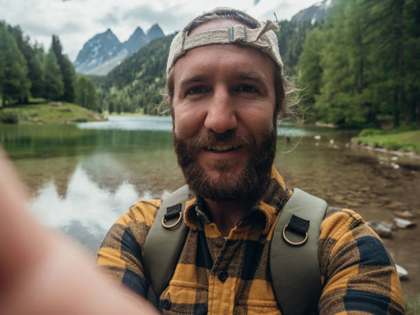 istock Man takes selfie at alpine lake 1301278273