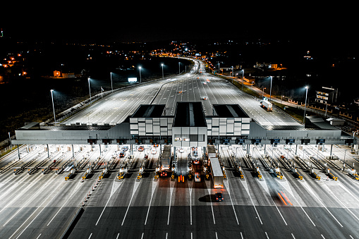 Pay toll collection point on motorway at night seen from a drone