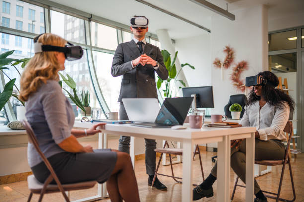istock Businessman with Virtual Reality Simulator Standing and Explaining About Project to Coworkers 1301284728