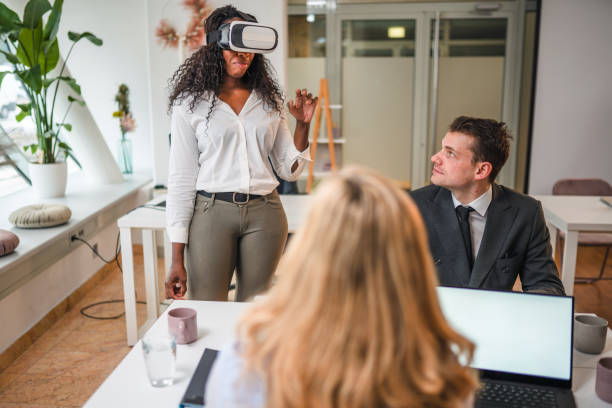 istock African Businesswoman with Virtual Reality Simulator Standing and Explaining About Project to Coworkers 1301284736