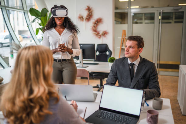istock African Businesswoman with Virtual Reality Simulator Standing and Explaining About Project to Coworkers 1301284739