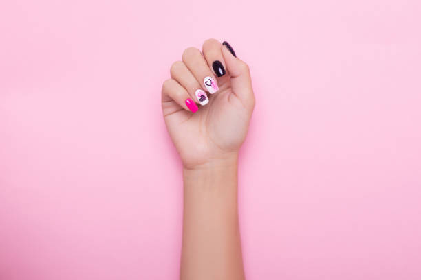 istock Female hand with romantic manicure nails, hearts design 1301289667