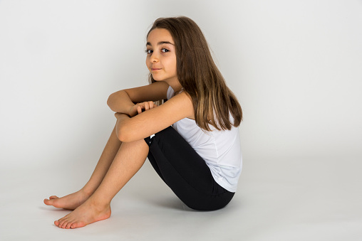 Photo of curious focused concentrated girl thinking on what should be placed instead of emptiness she looks at while isolated with white background.Serial