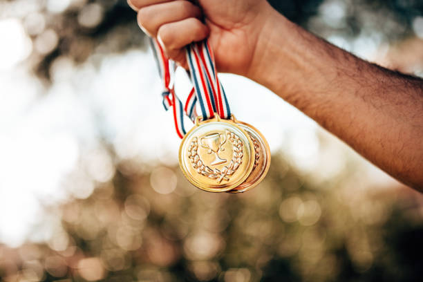 holding the medals for the winning