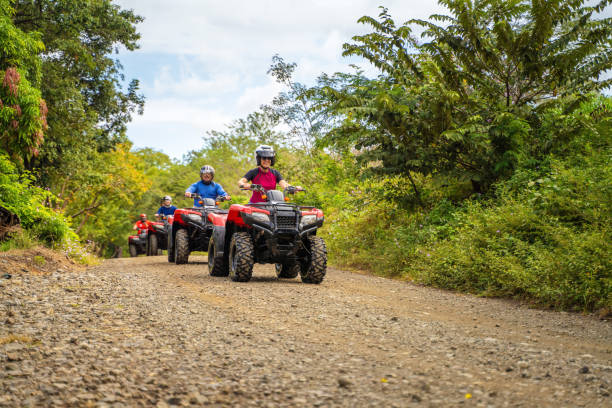 Group of latin tourists driving a 4x4 bike in Costa Rica Group of latin tourists driving a 4x4 bike in Costa Rica off road vehicle stock pictures, royalty-free photos & images
