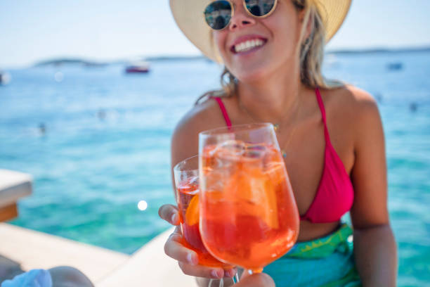 istock Couple toasting with a spritz cocktail on a deck beside the ocean. 1301295077