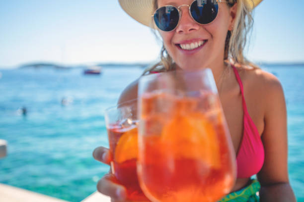 istock Couple toasting with a spritz cocktail on a deck beside the ocean. 1301295078