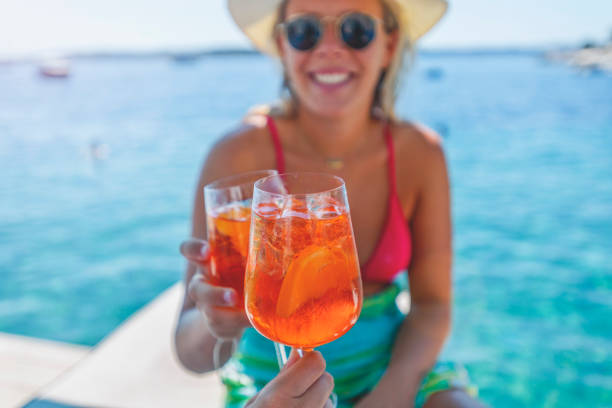 istock Couple toasting with a spritz cocktail on a deck beside the ocean. 1301295086